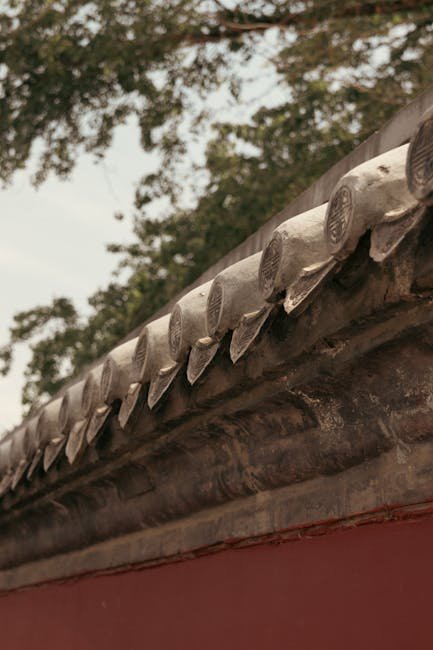 Intricate wood carving detail on a Huizhou-style ancestral hall beam, showing traditional motifs and craftsmanship